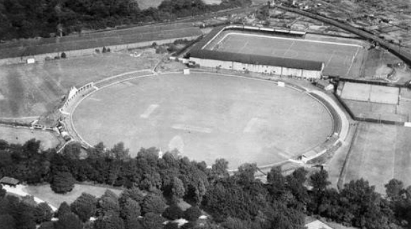 Old black and white photograph of an old arena and trees