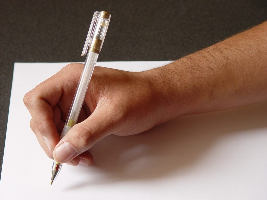 A person about to start writing on a blank piece of paper